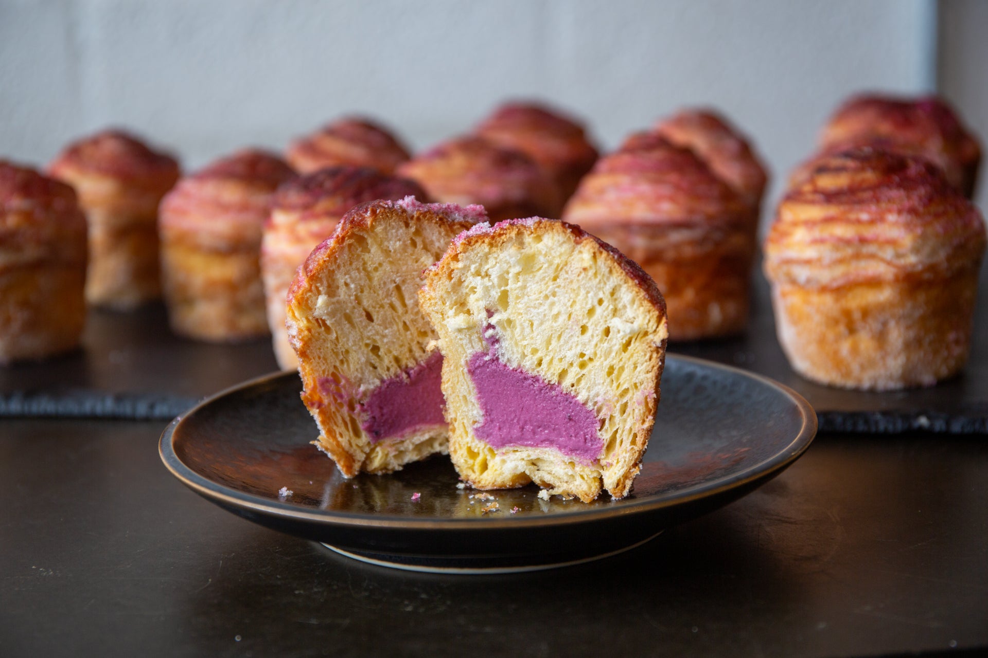 A cross-section of a blackcurrant cheesecake cruffin