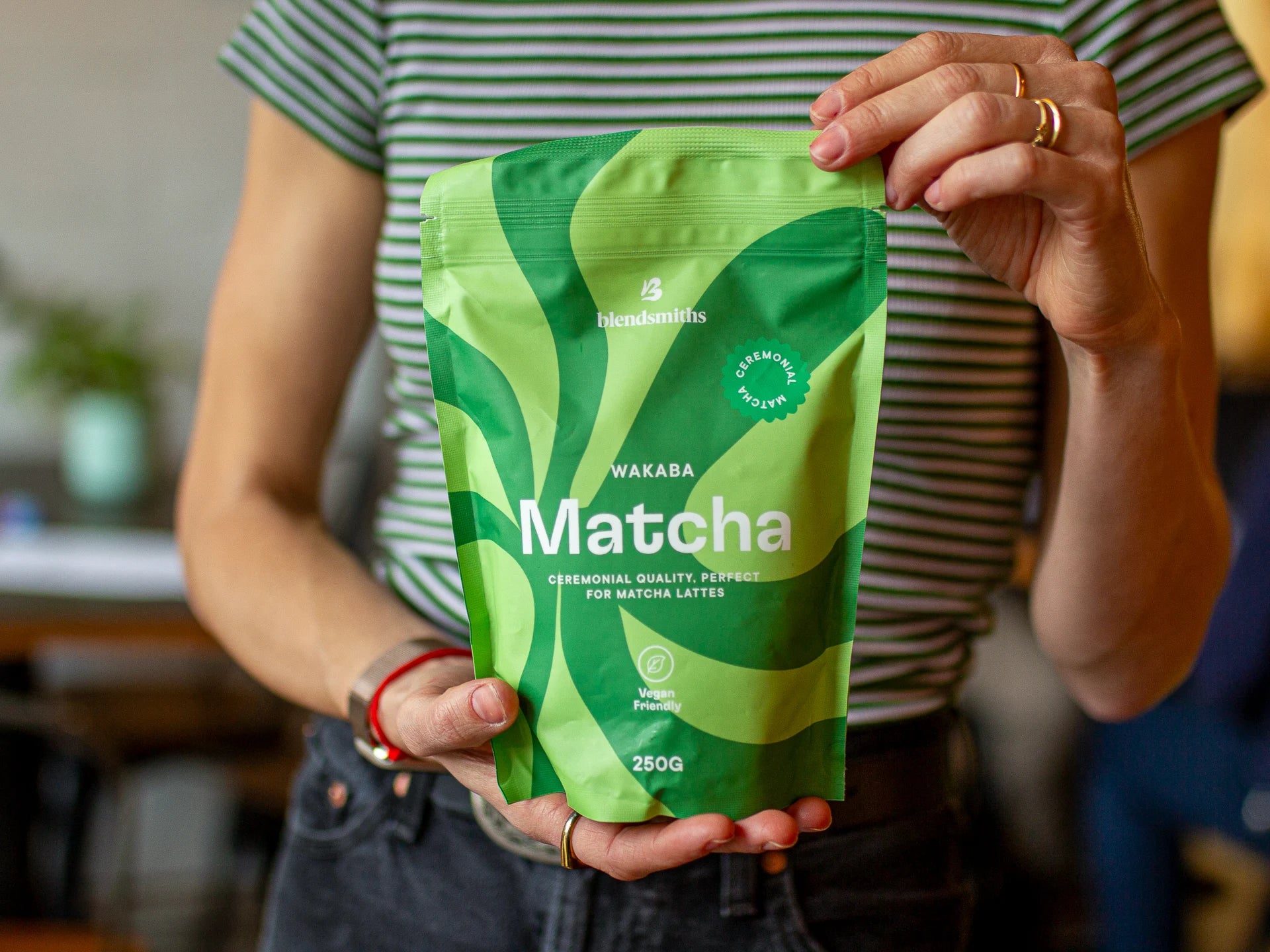 Person holding a green package of Ceremonial-Quality Wakaba Matcha