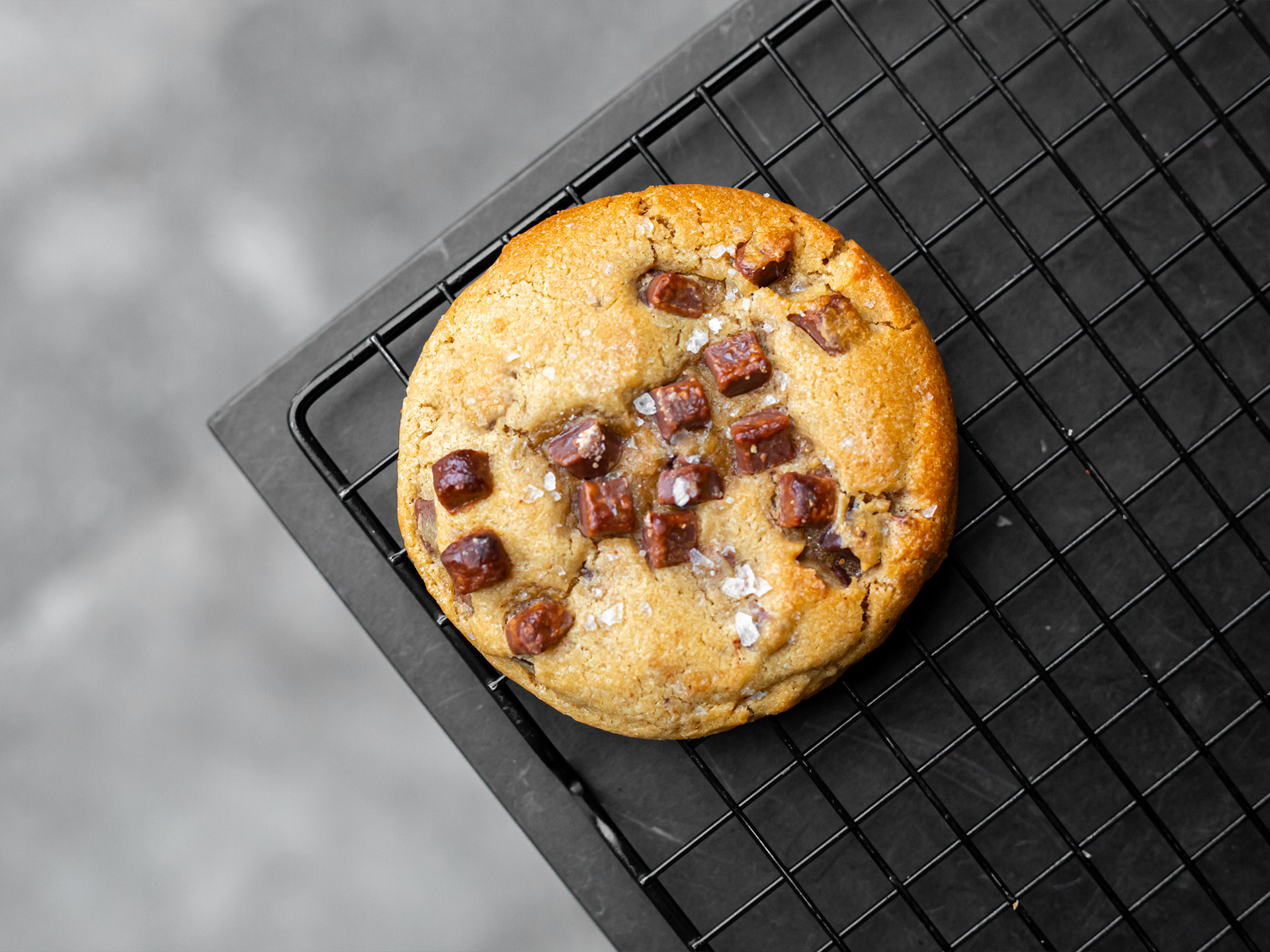Chocolate Chip Sea Salt Cookie with chocolate chunks on a cooling rack
