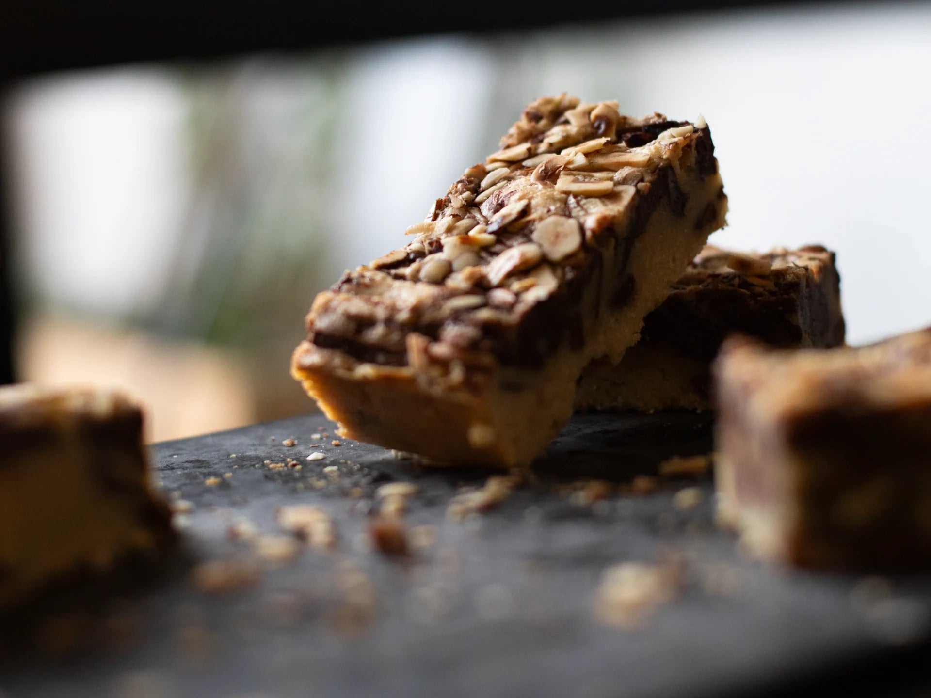 Close-up of a chocolate Hazelnut Blondie bar with nuts on a dark surface