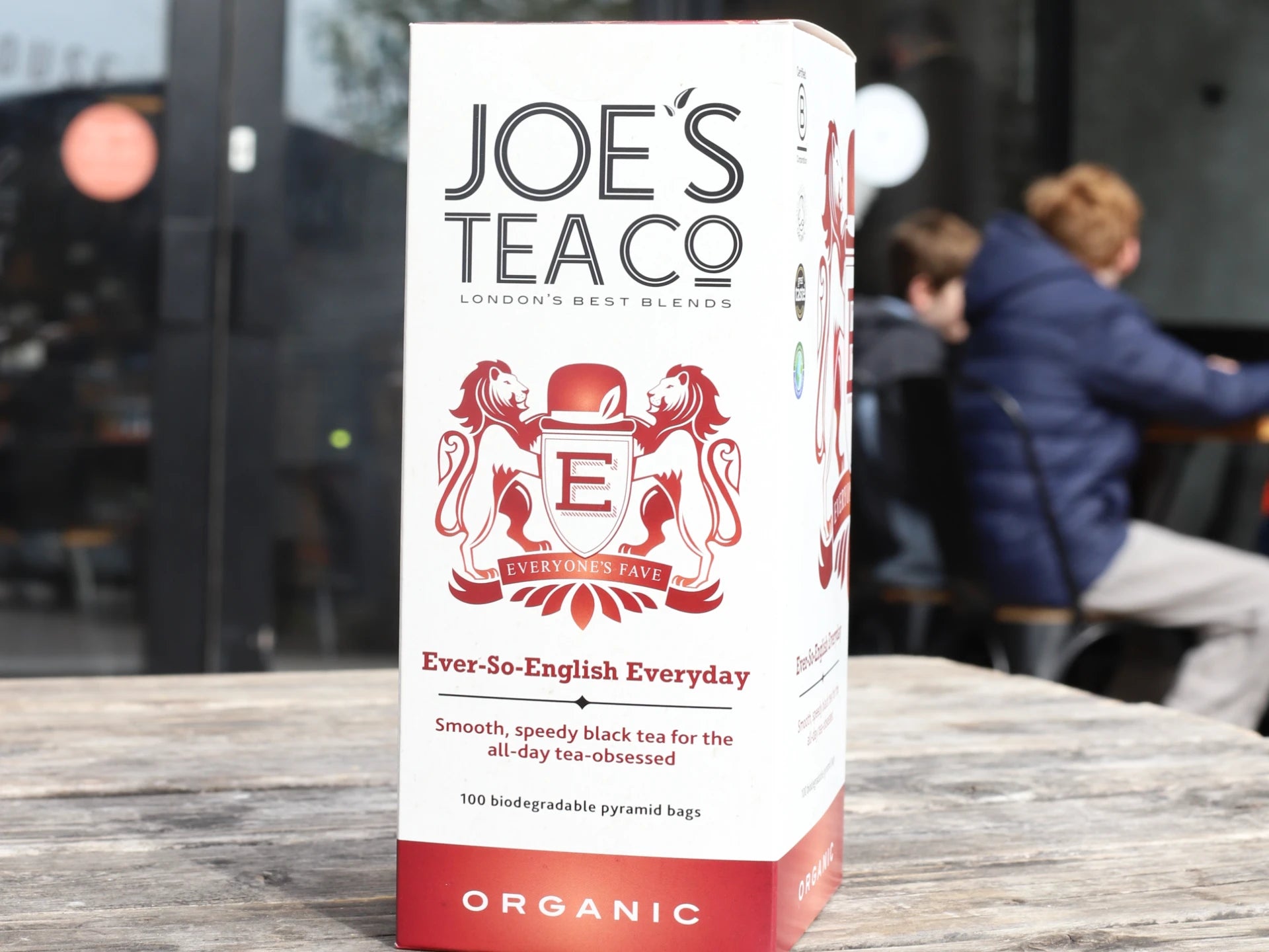 Box of Joe's Tea Co - Ever-So-English Breakfast tea on a wooden table with people in the background