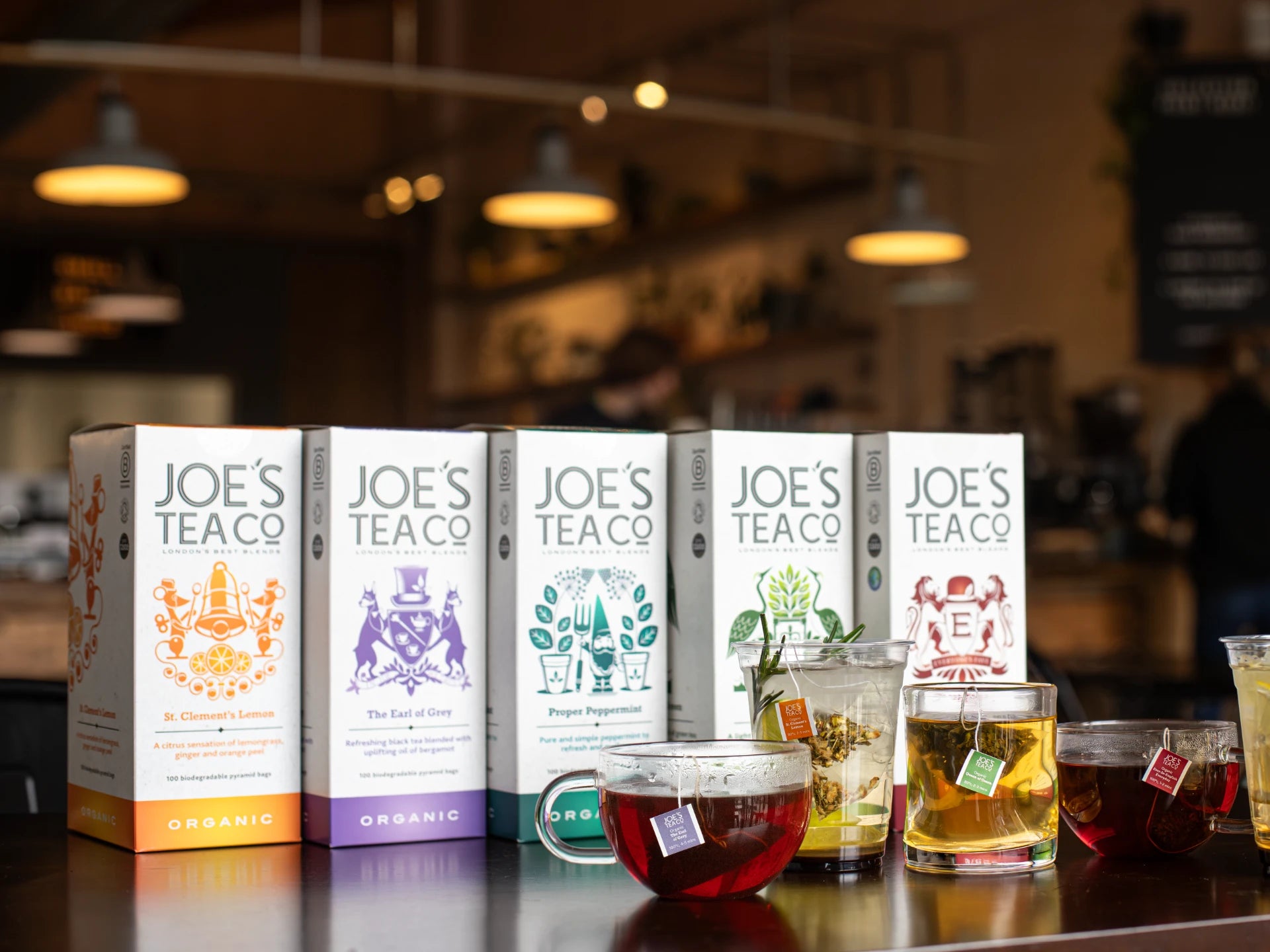 Joe's Tea Co. tea boxes with brewed tea on a bar counter.