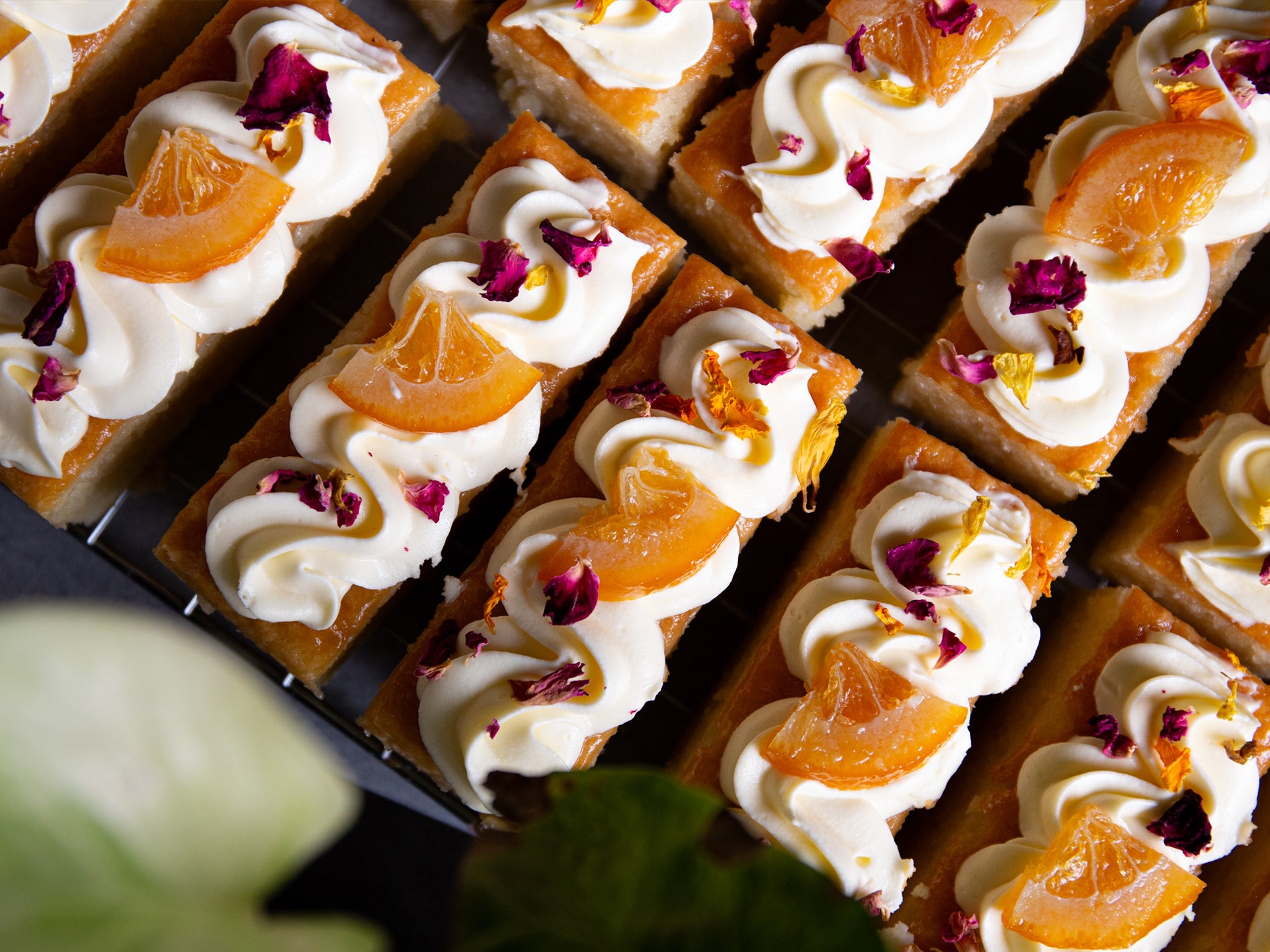 Slices of St Clements traycake with orange slices and buttercream