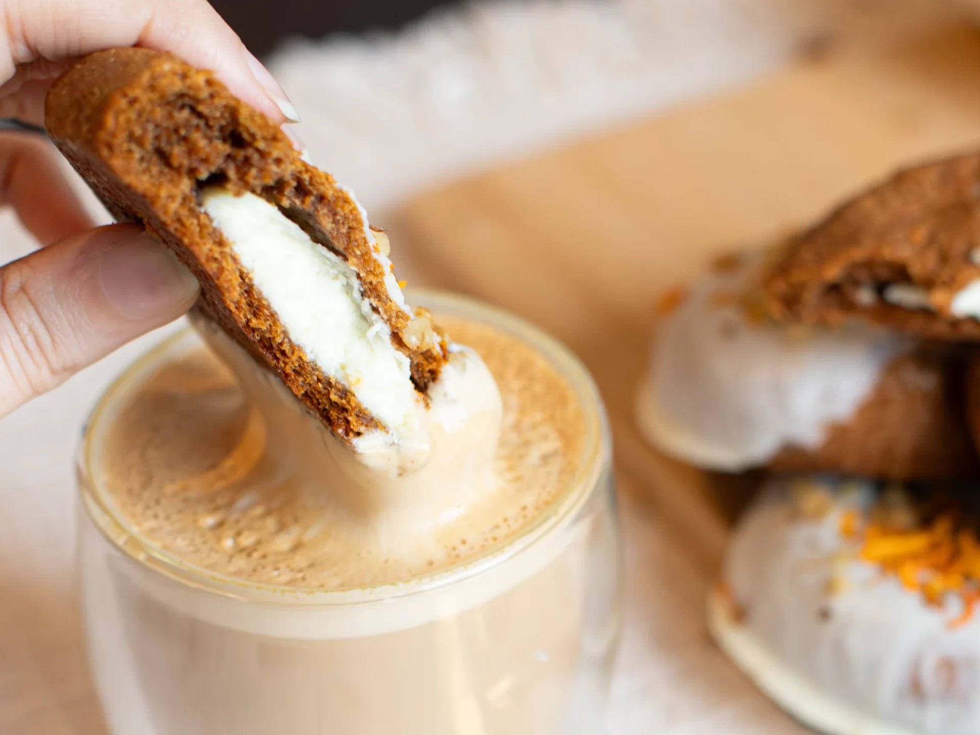 Carrot Cake Cookie with cream centre being dunked in coffee