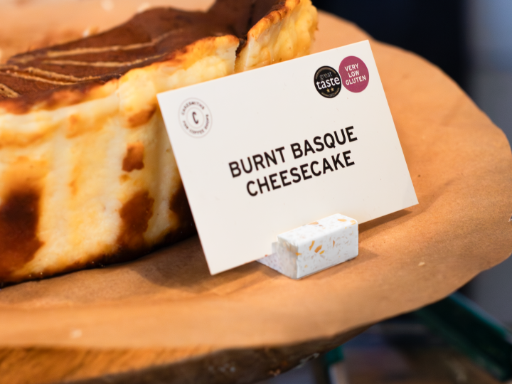 Burnt Basque Cheesecake with a sign indicating the name of the dessert on a wooden board.