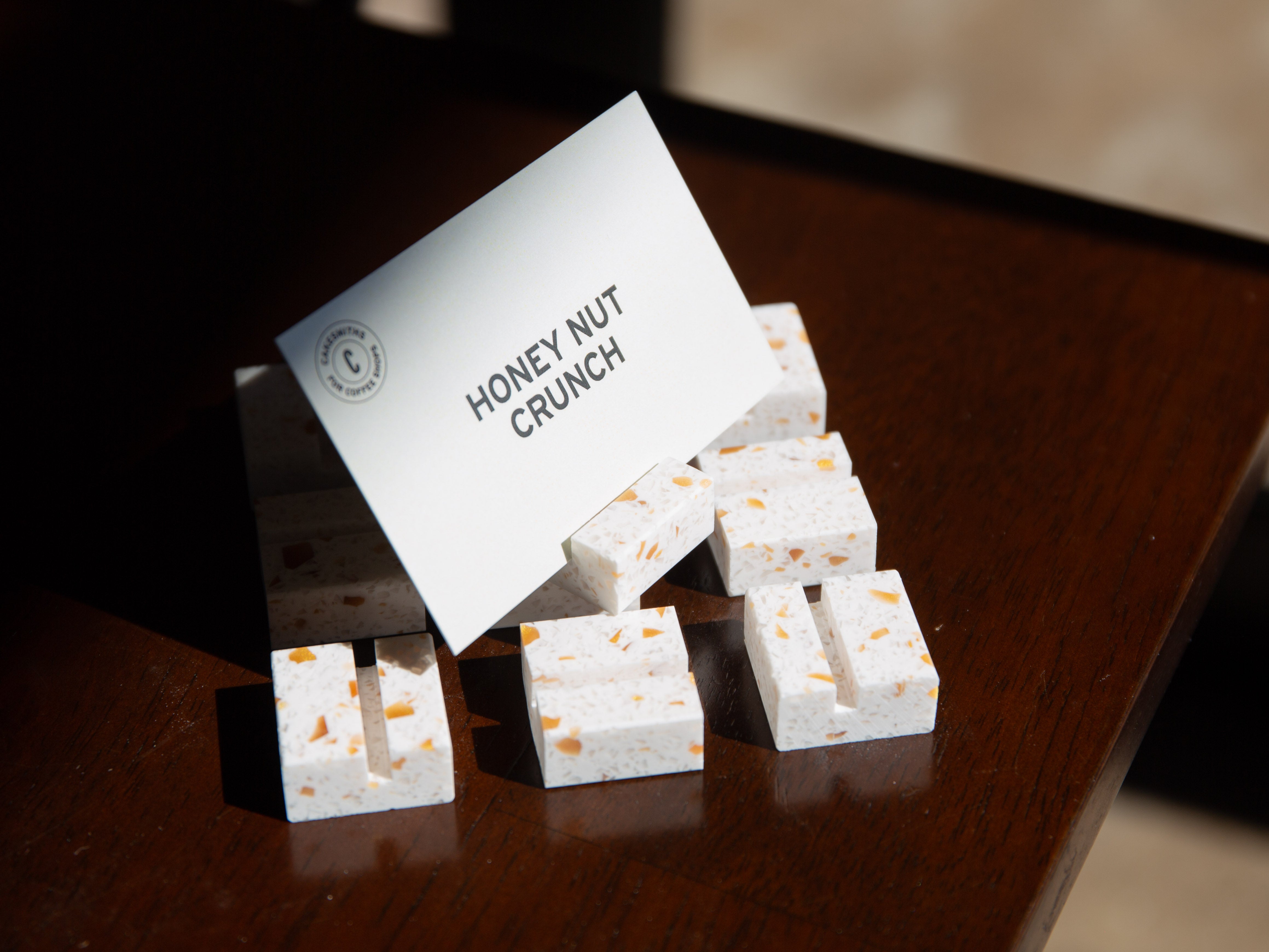 Nougat Product Display Card Stands White cubes with honey nut flavor label on a wooden surface