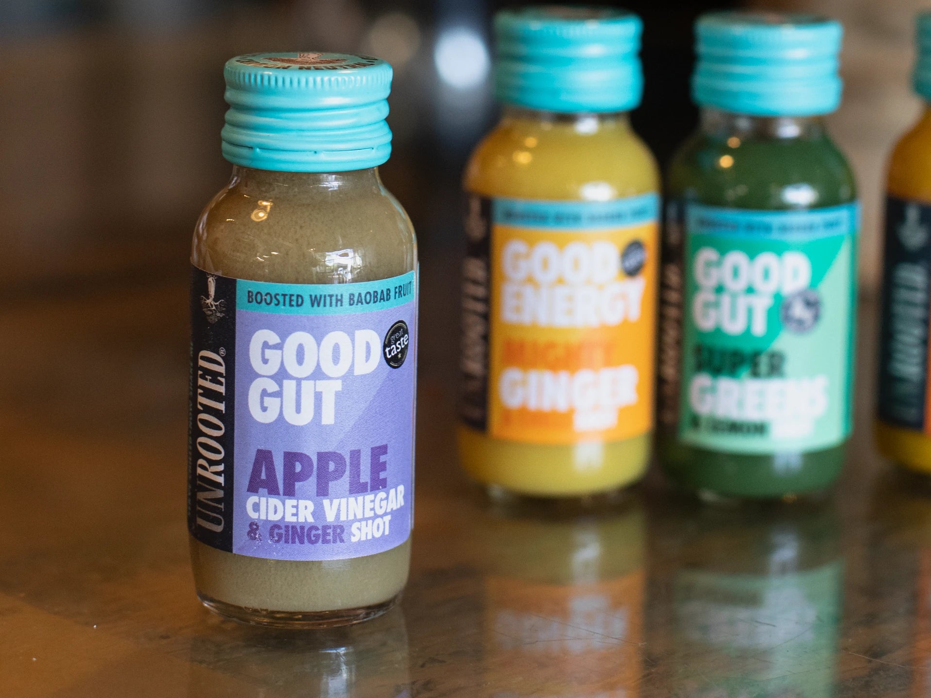 Unrooted Health Shots and other health-focused shots on a reflective surface.