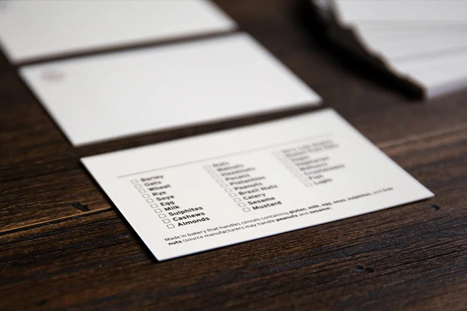 The back of our blank white product display cards with a list of allergens to tick on the back