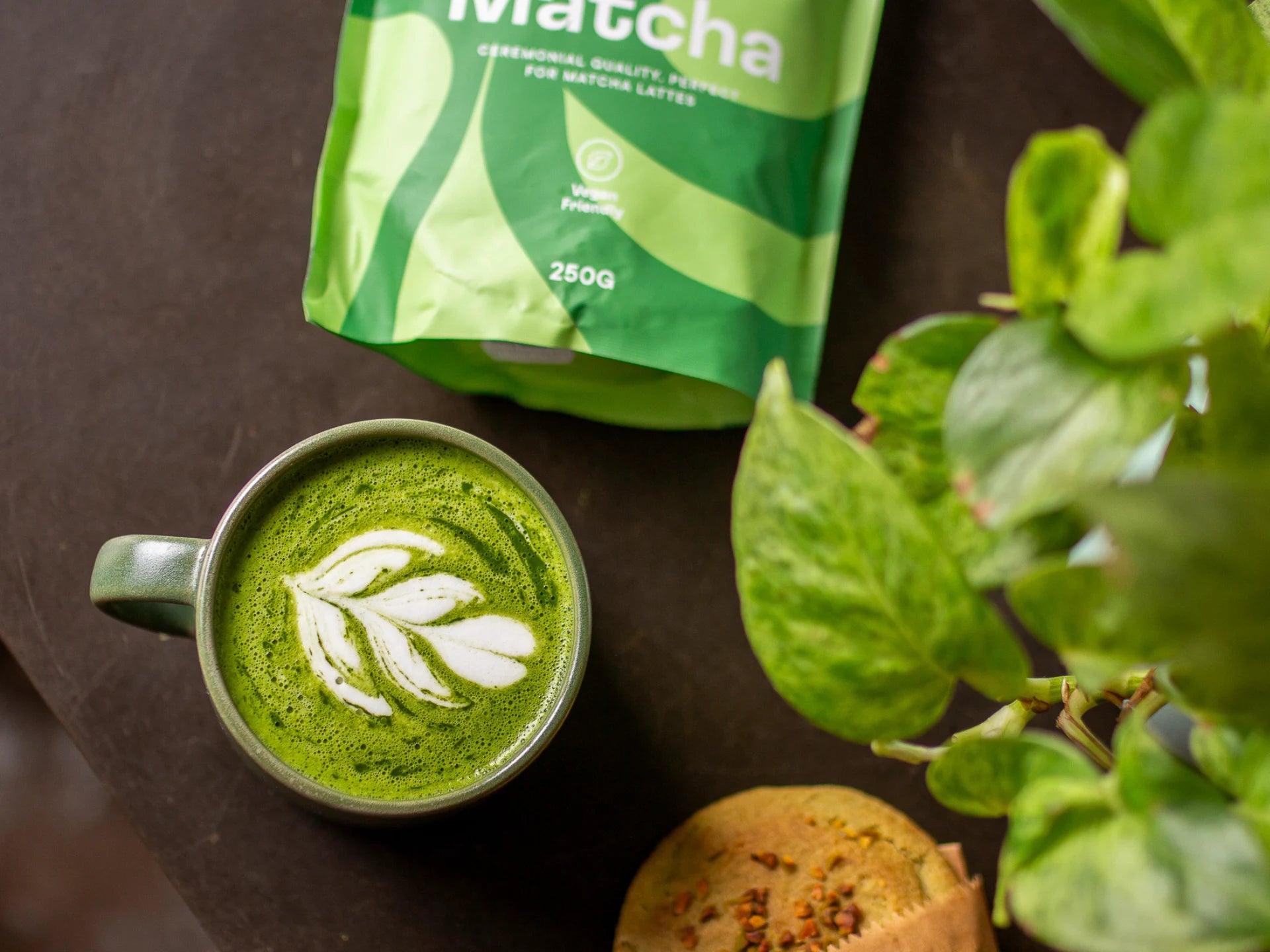 Ceremonial-Quality Wakaba Matcha green tea powder package with a cup of matcha and a plant on a dark surface