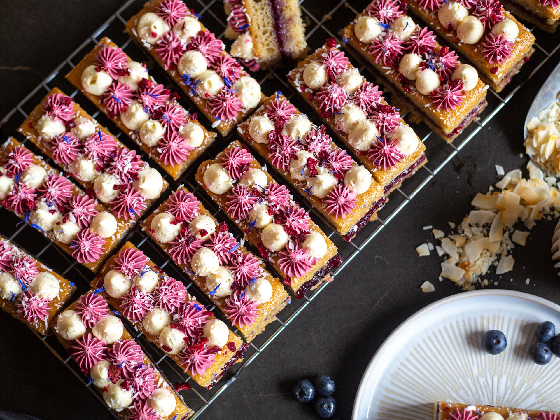 A tray of wholesale coconut cakes with blueberry frosting