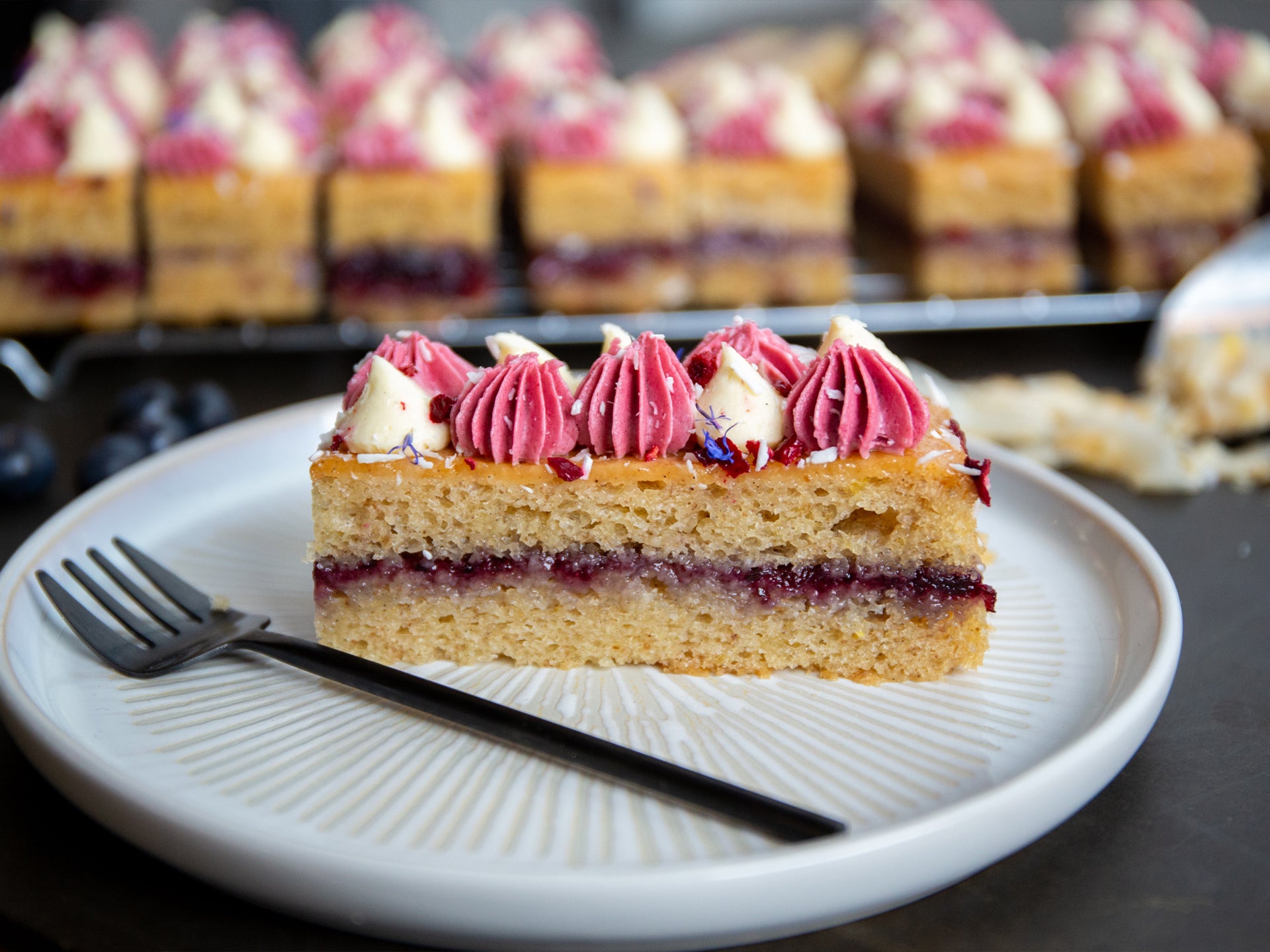 Slice of coconut cake with blueberry frosting