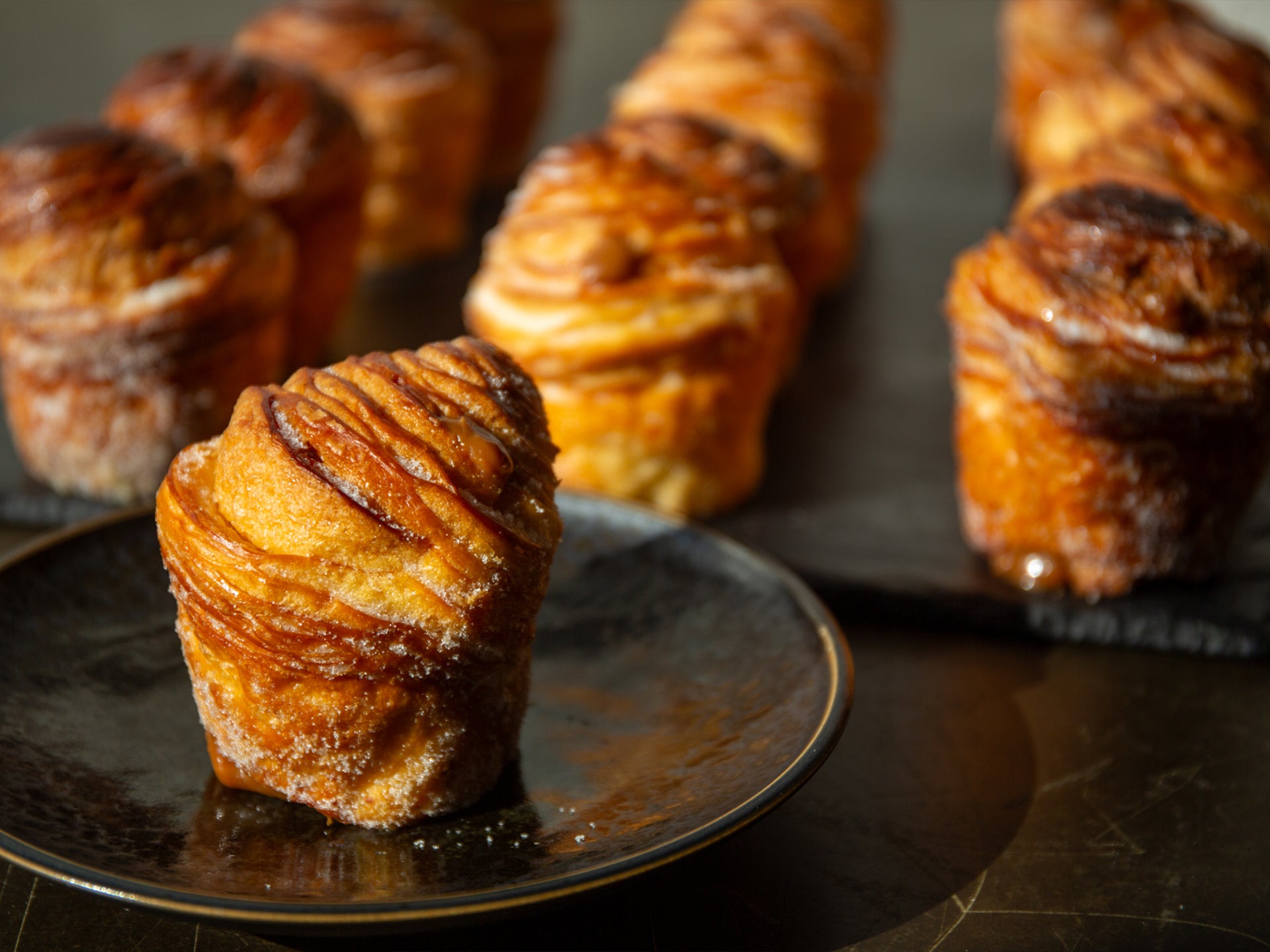 Close up of a golden dulce de leche filled wholesale cruffin