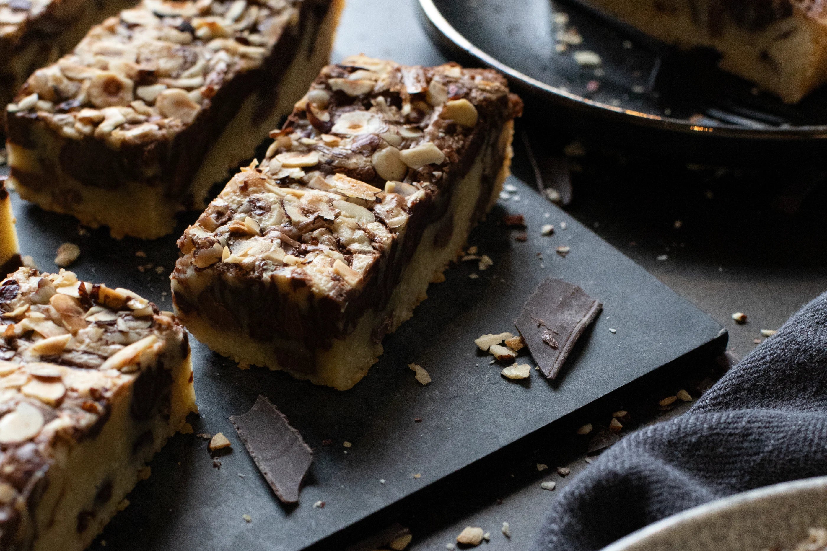 Hazelnut Blondie bar on a dark surface with a blue napkin
