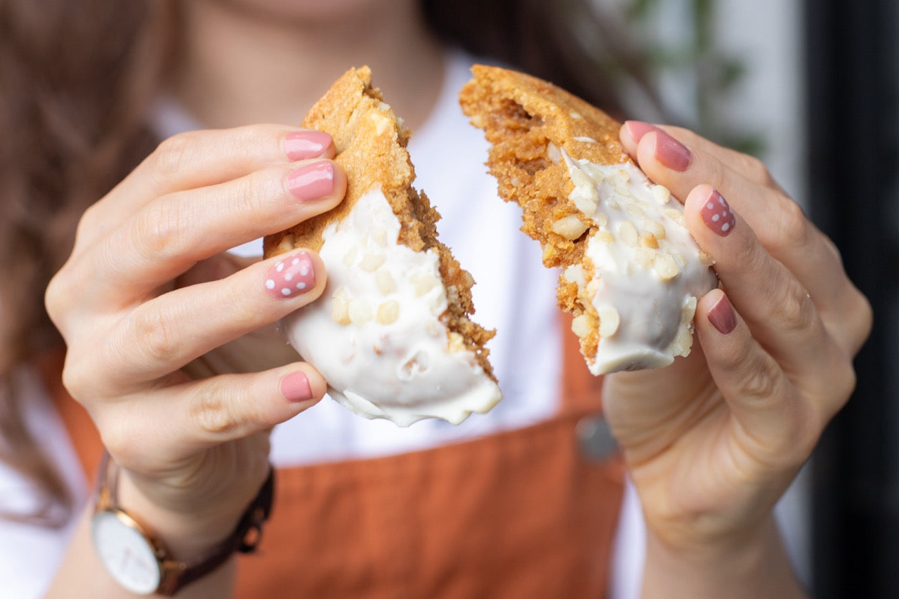 Person holding two halves of a Miso Cookies with white filling