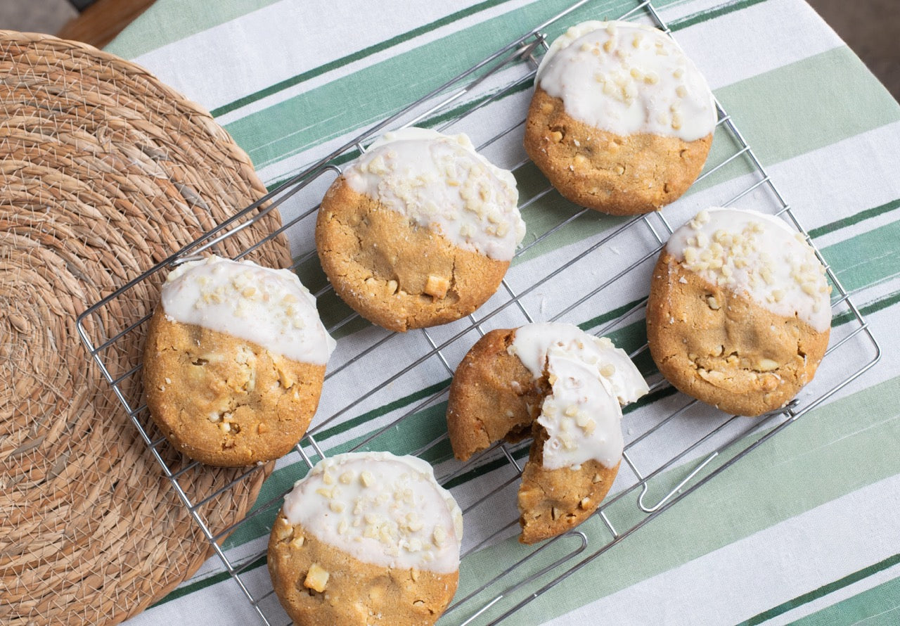 Miso Cookies with white icing on a cooling rack on a striped surface