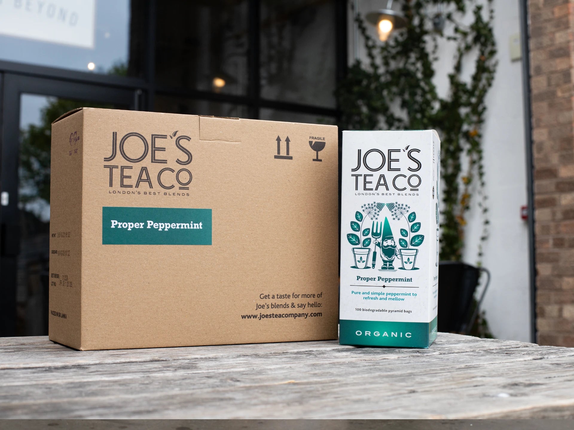 Joe's Tea Co packaging including a cardboard box and a tea bag on a wooden surface.