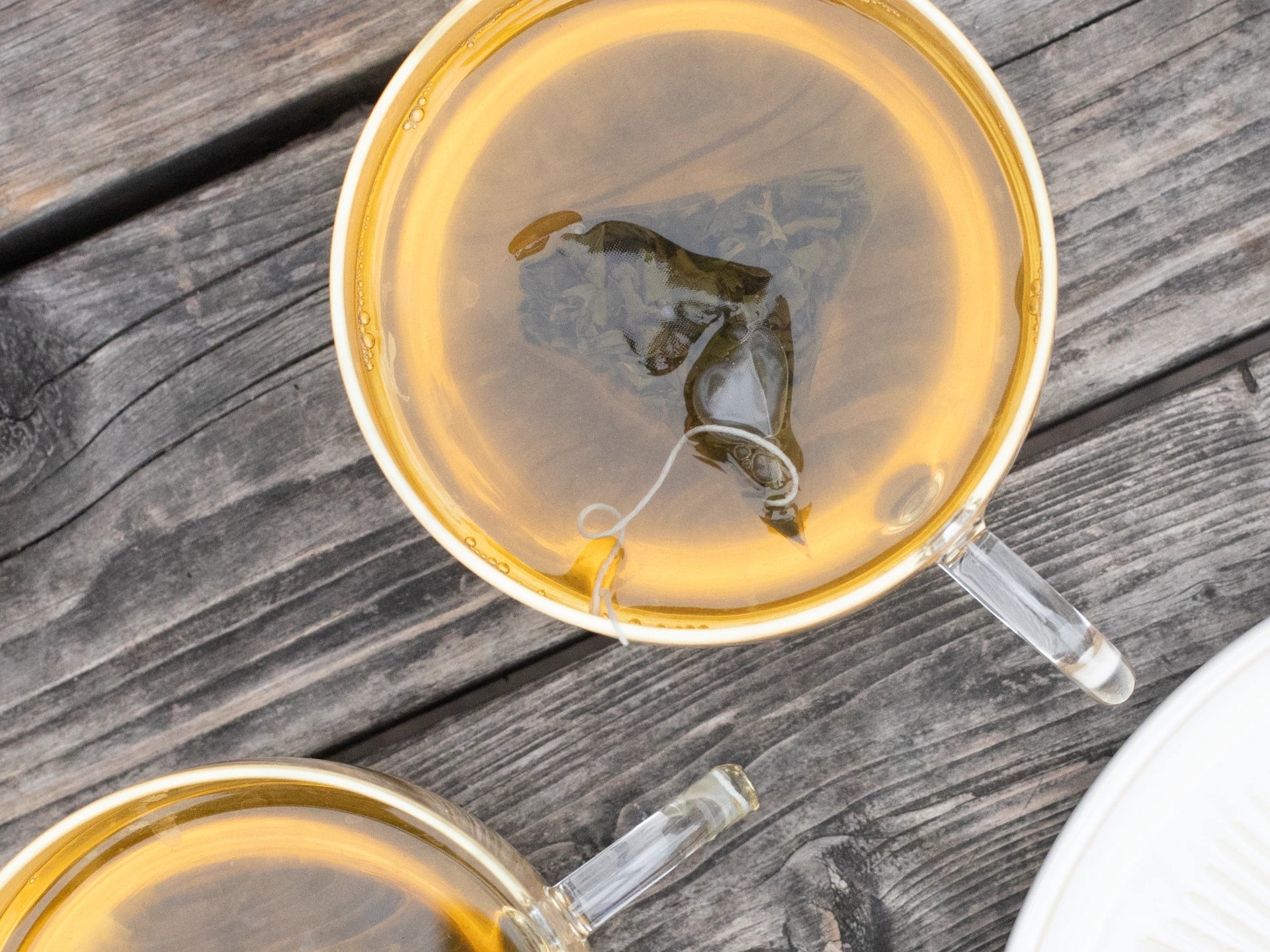Joe's Tea co Tea in a clear glass teacup on a wooden surface