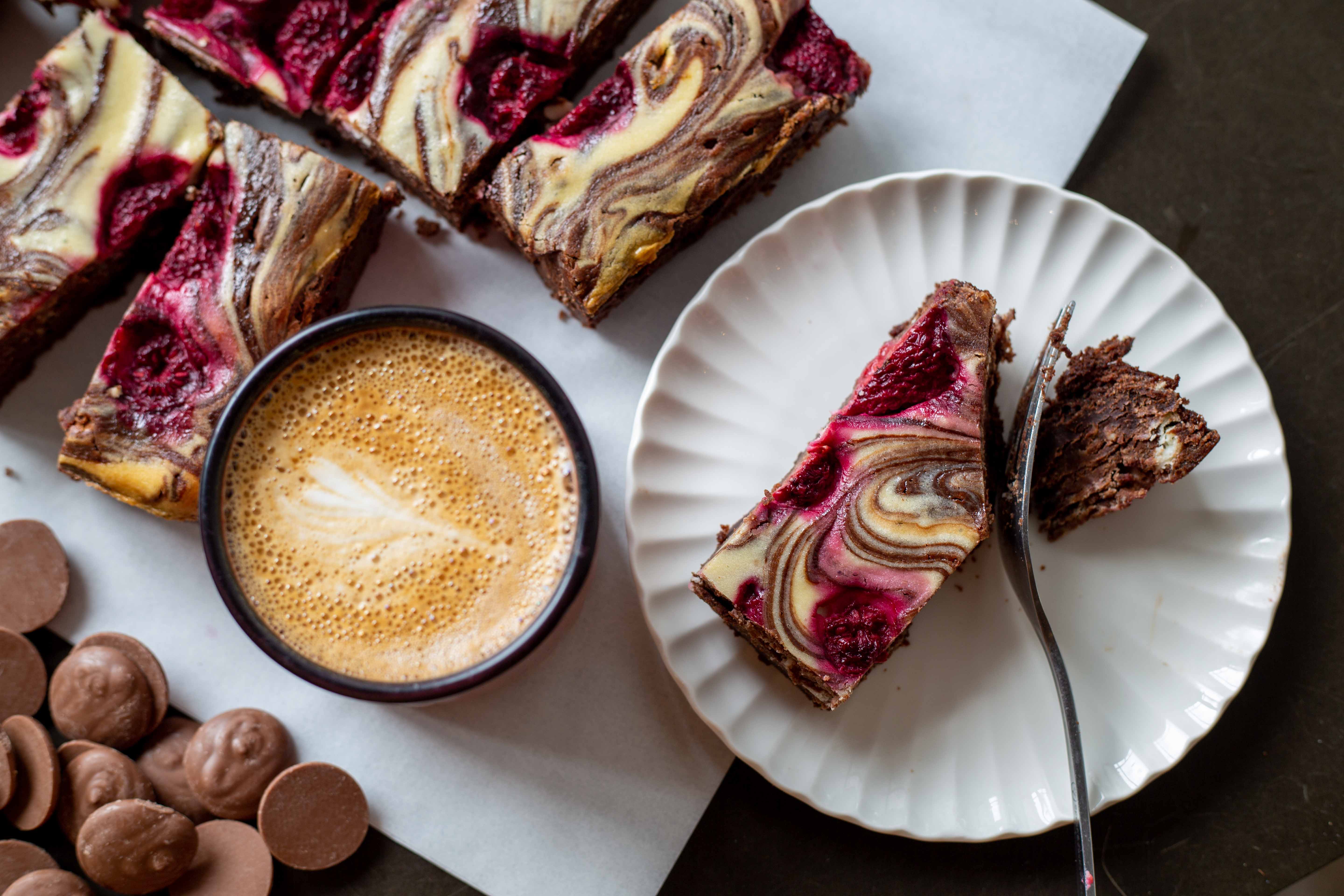 A slice of our wholesale brownies with raspberries and a cheesecake swirl