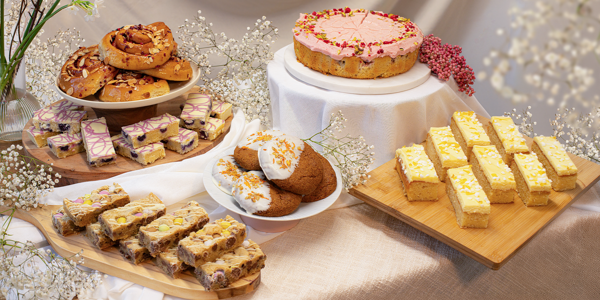 Assorted Spring pastries and cakes displayed on a table with a decorative background