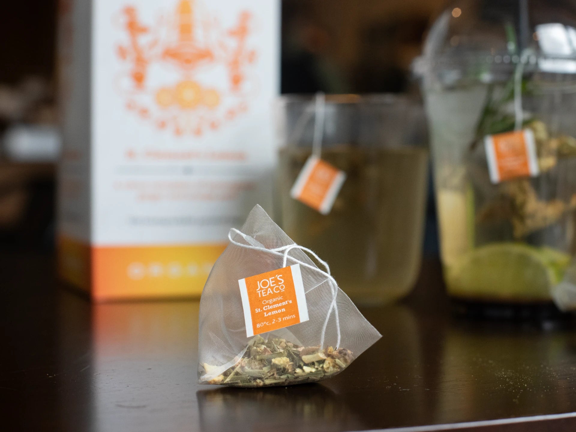 Tea bag with Joe's Tea packaging on a wooden surface