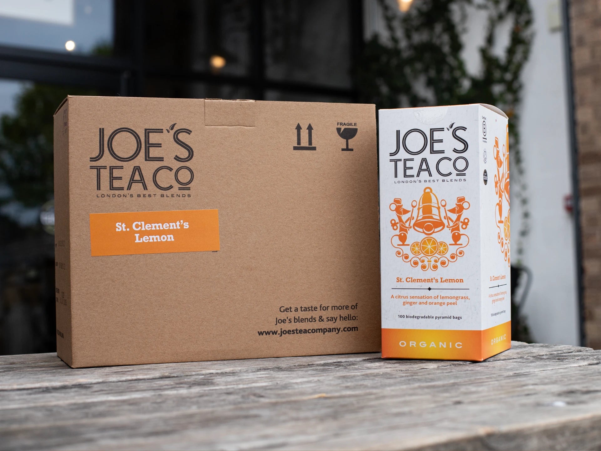 Joe's Tea Co. packaging including a cardboard box and a tea bag on a wooden surface.