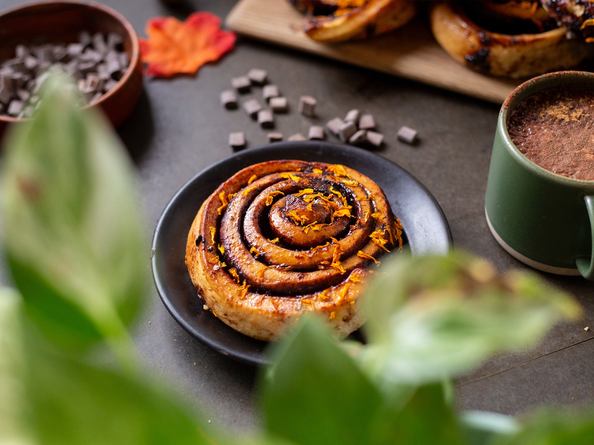 A wholesale chocolate orange sticky bun served with hot chocolate