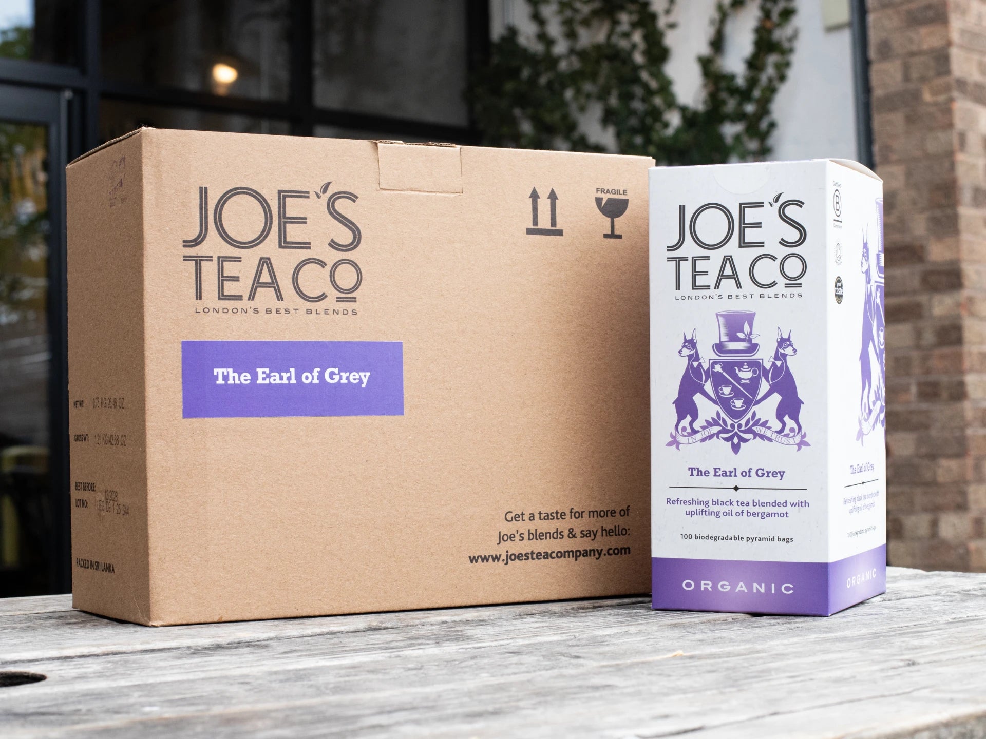 Joe's Tea Co. packaging including a cardboard box and a tea bag on a wooden surface.