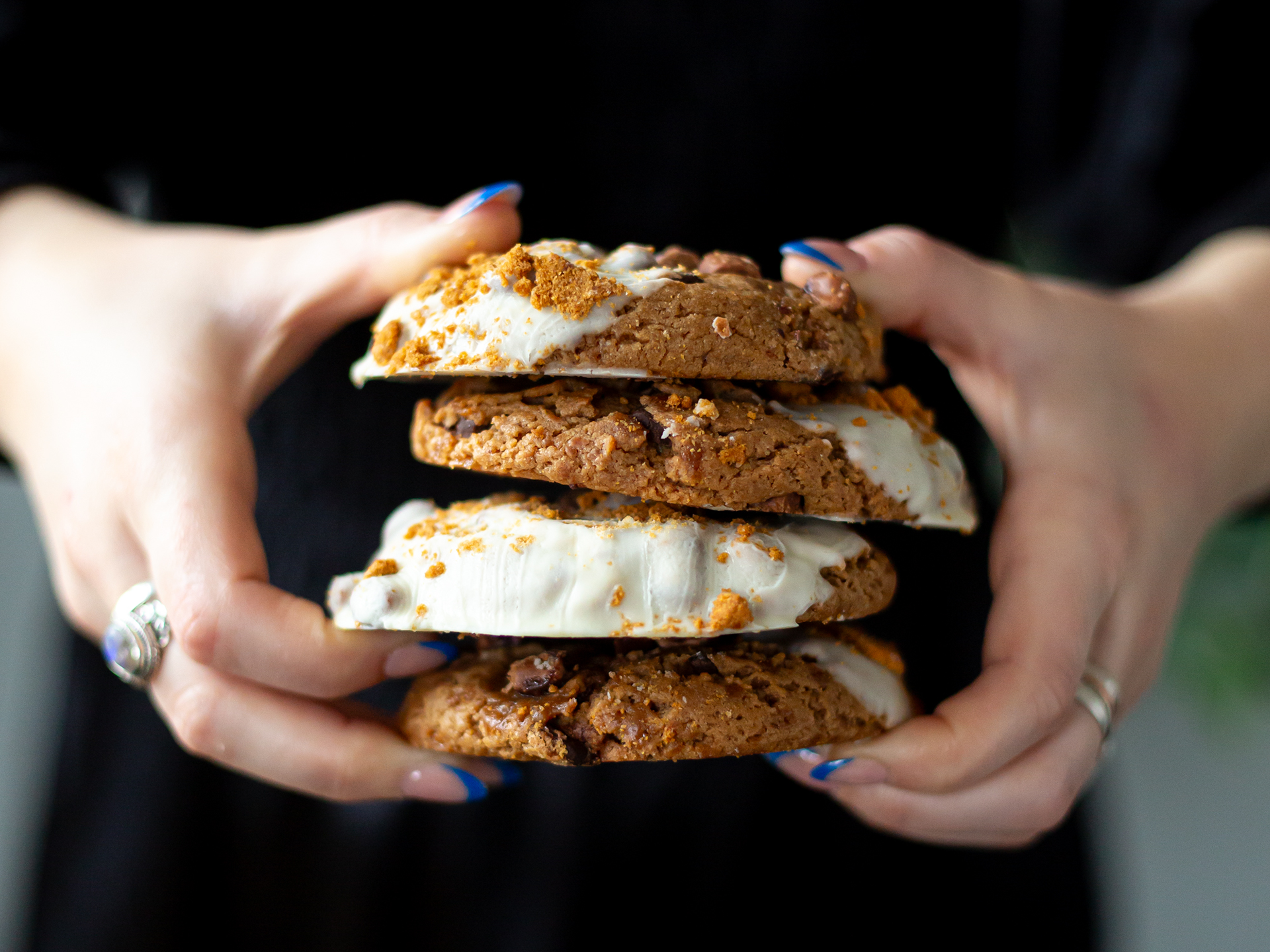 Stack of s'mores cookies held by a person with a blurred background