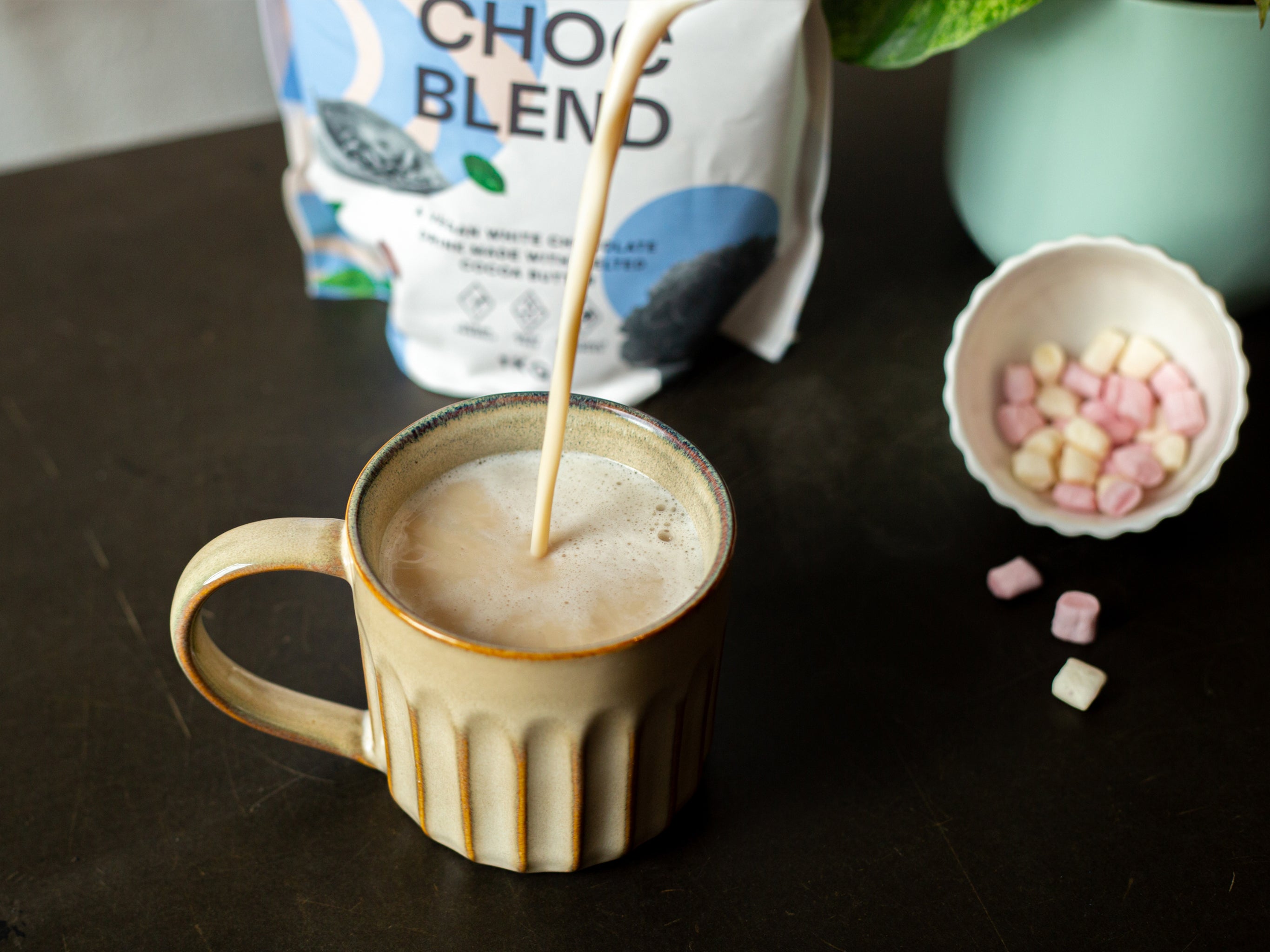 A mug of white hot chocolate, with extra marshmallows all made using Blendsmiths products available from Cakesmiths