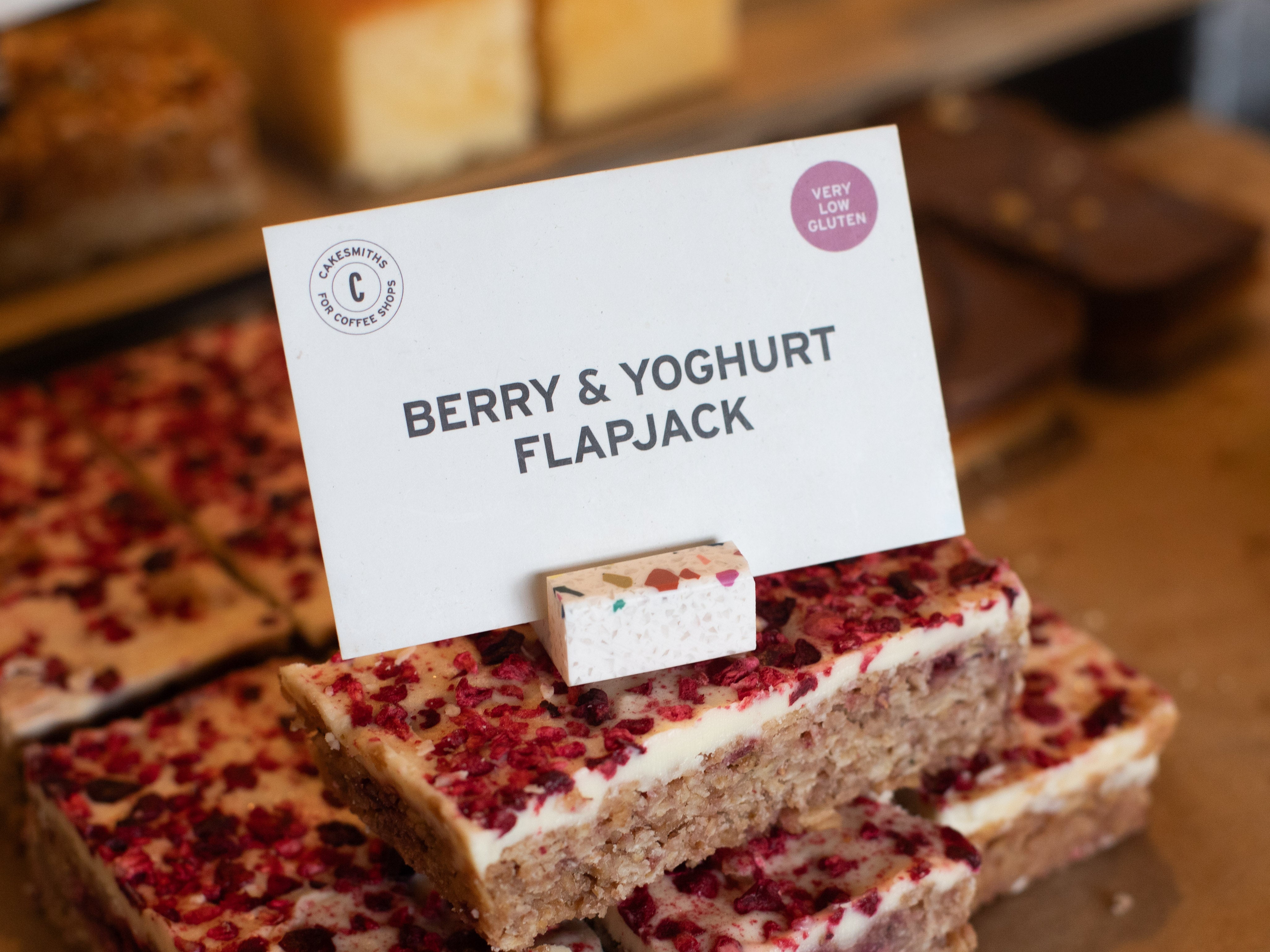 Berry and yoghurt flapjack with a Confetti Product Display Card Stands sign indicating the flavor and brand.