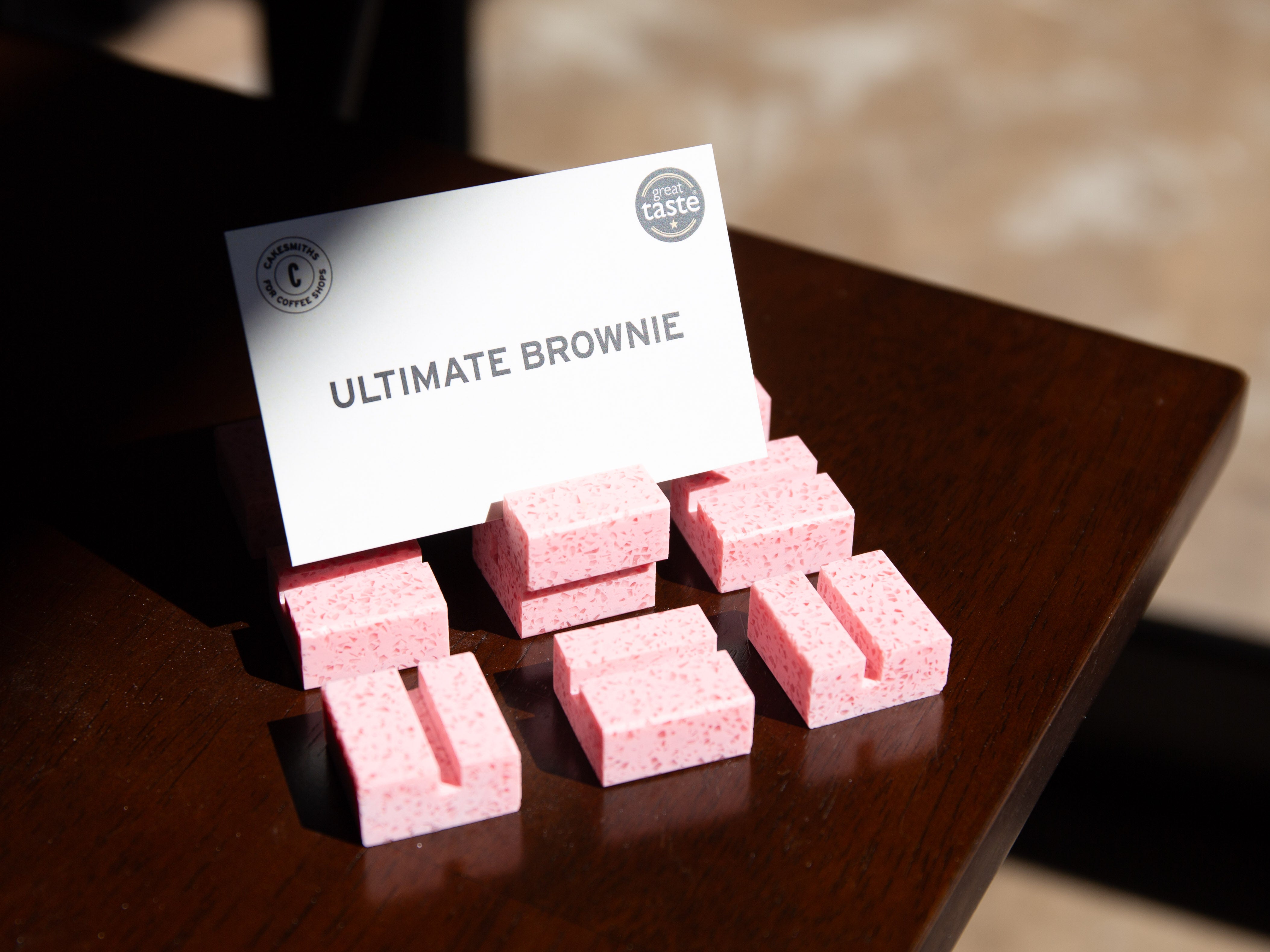 Bubblegum Product Display Card Stands blocks with a card labeled 'Ultimate Brownie' on a wooden surface.