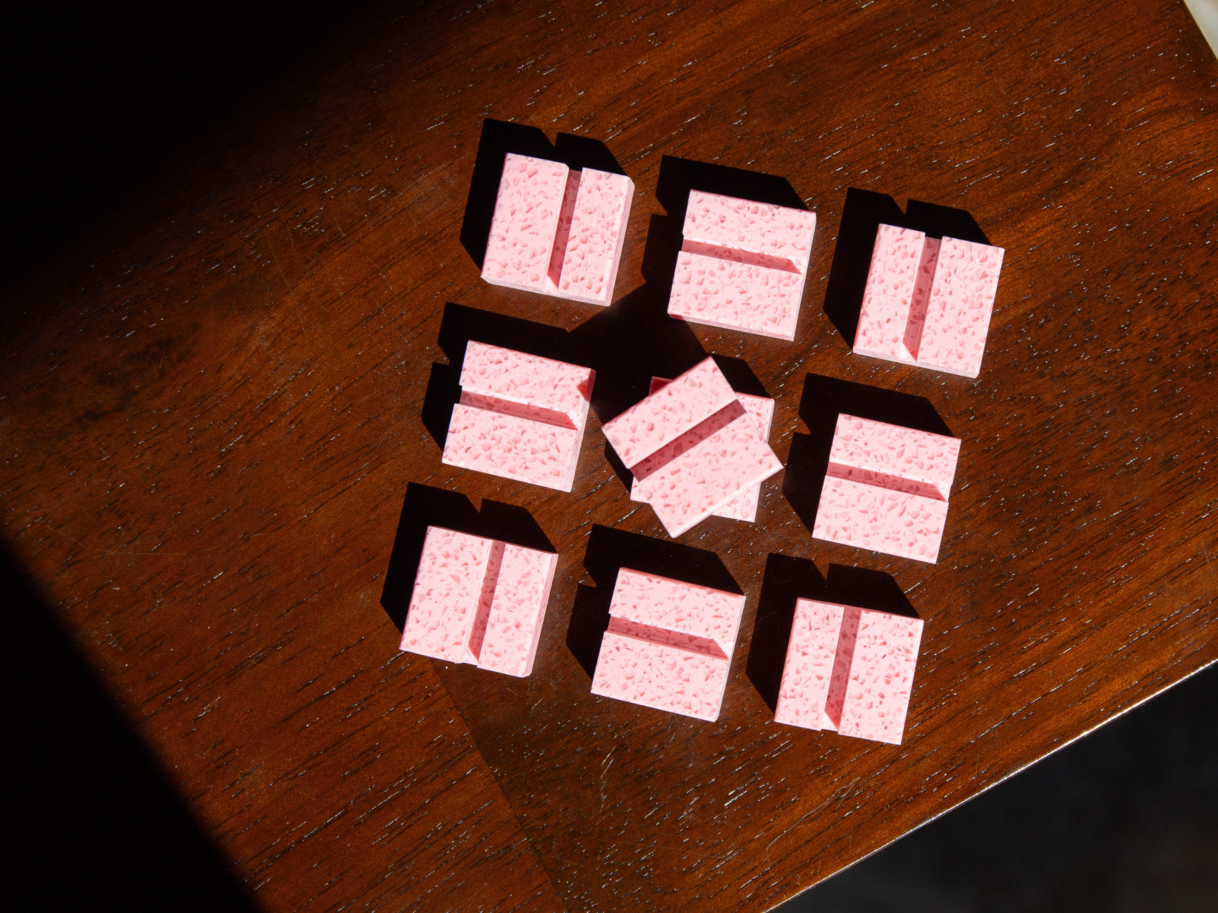 Small pink Bubblegum Product Display Card Stands  with red stripes on a wooden surface